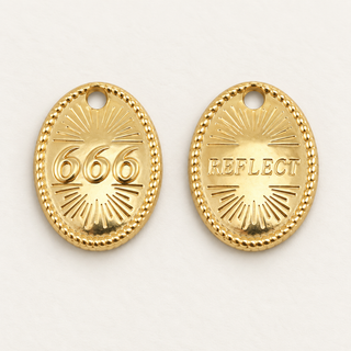 Goldener Engelszahlen-Charm 666 mit Rückseite REFLECT auf cremefarbenem Hintergrund.