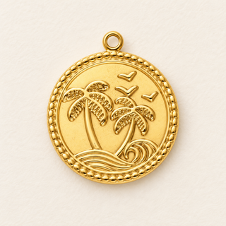 Goldfarbener runder Edelstahl-Charm mit zwei Palmen, Welle und Vögeln auf hellem Hintergrund.