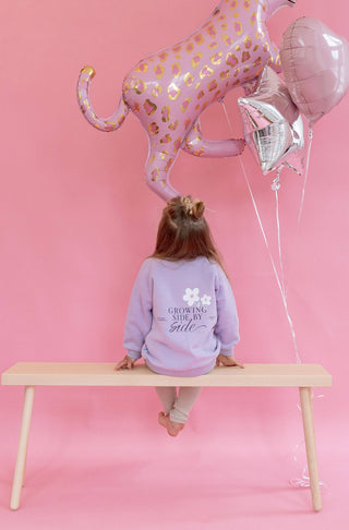 Lillafarbeneder Kinderpullover mit Blumenprint und Growing Side by Side Schriftzug