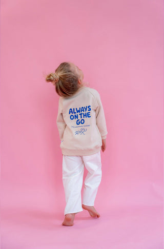Kinderpullover in hellem beige mit blauer Schrift Always in the go (big adventures involved)