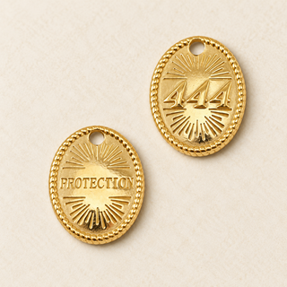 Vorder- und Rückseite eines goldfarbenen ovalen Edelstahl-Charms mit Engelszahl 444, Schriftzug Protection und Strahlenmotiv.