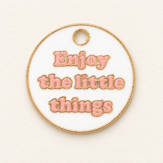 Runder Charm in Gold, Weiß und Rosa für deinen Wish Keeper. „Enjoy the little things“ erinnert an Achtsamkeit, Dankbarkeit und die kleinen Glücksmomente.