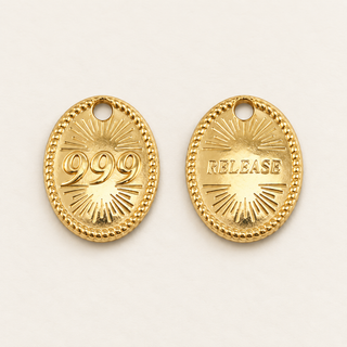 Goldener Engelszahlen-Charm 999 mit Rückseite RELEASE auf cremefarbenem Hintergrund.