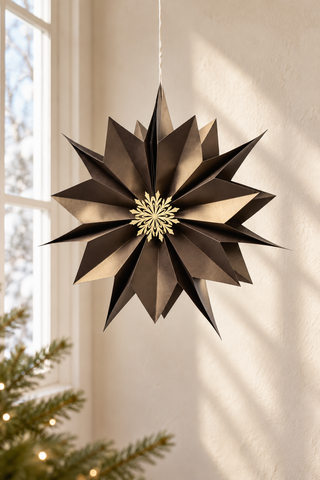 Coffee-brauner Papierstern Pearl mit goldfarbenem Ornament, 60 cm Durchmesser, vor einer hellen Wand aufgehängt