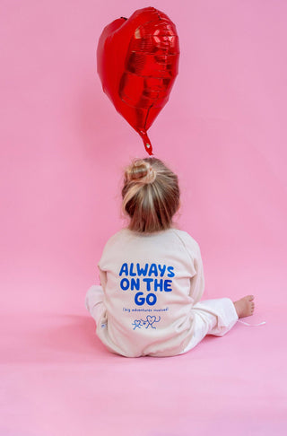 Kinderpullover in beige mit blauer Schrift Always on the go (big adventures involved)