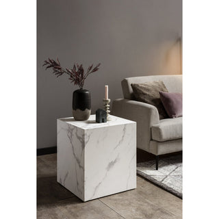 beistelltisch würfel aus marmor mit sof aim hintergrund und vasen mit kerzen und haus auf dem Tisch